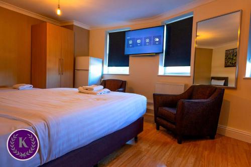 a hotel room with a bed and a chair at Kingfisher Court Apartments by UNO in Slough
