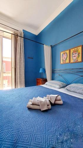 a blue bedroom with a bed with towels on it at Stella del Sud in Catania