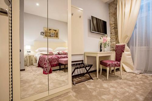 a bedroom with a bed and a table and a mirror at Heritage Hotel Antique Split in Split
