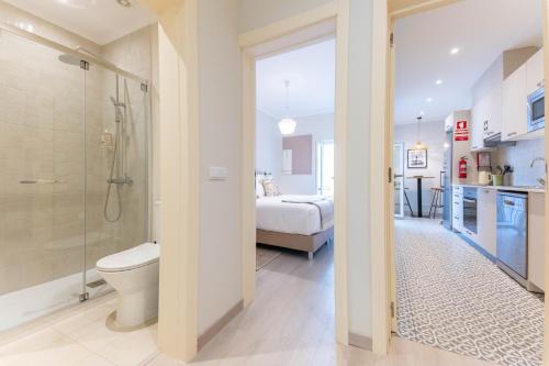 a bathroom with a shower and a toilet and a bedroom at Casa da Avenida 1 - Centro - Private Terrace in Tavira