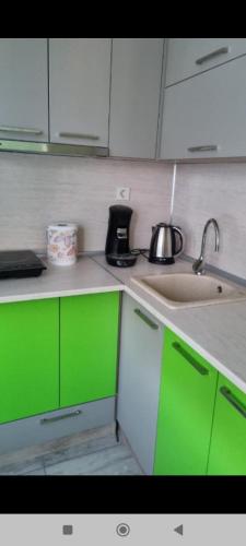 a kitchen with green and white cabinets and a sink at Apartment Medika 2 in Ruse