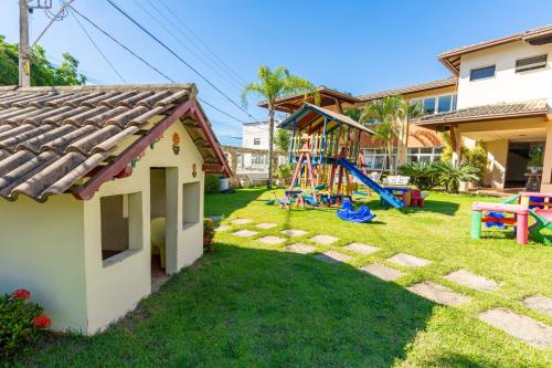 a yard with a playground and a house at Hotel Meaípe in Guarapari