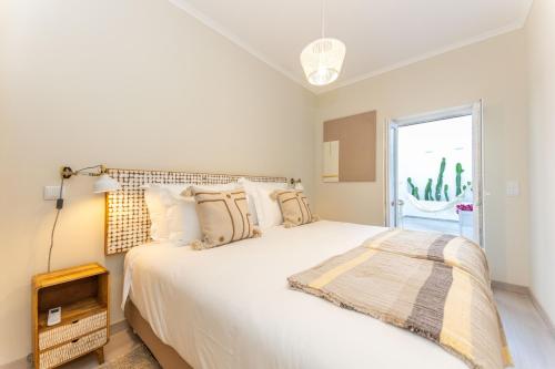 a bedroom with a large white bed with a window at Casa da Avenida 1 - Centro - Private Terrace in Tavira