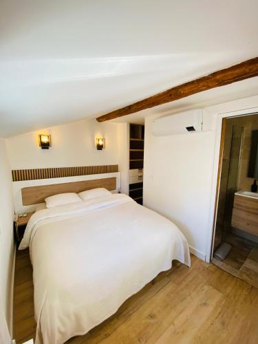 une chambre avec un grand lit blanc avec des draps blancs dans l'établissement APPARTEMENT en DUPLEX VIEUX NICE, à Nice