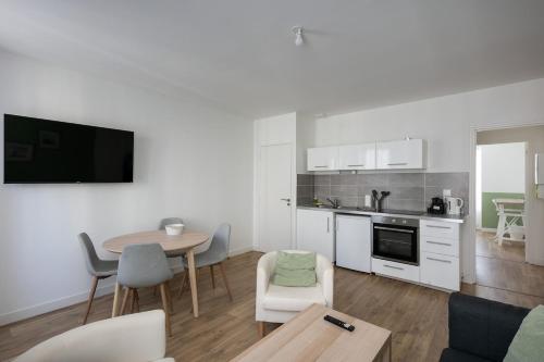 un salon avec une table et une cuisine dans l'établissement T3 Far, à Brest