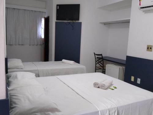 a room with two beds and a flat screen tv at One Hotel in João Pessoa