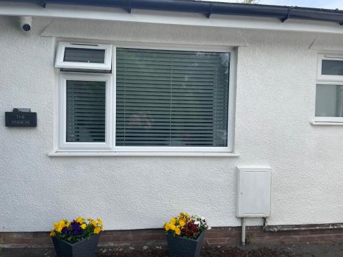 a house with two windows with flowers in front of it at The Annexe in Felton