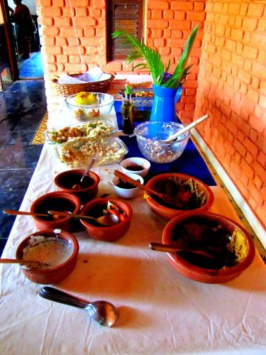 a table with bowls of food and spoons at Bohemyan Blue Stay in Alibaug