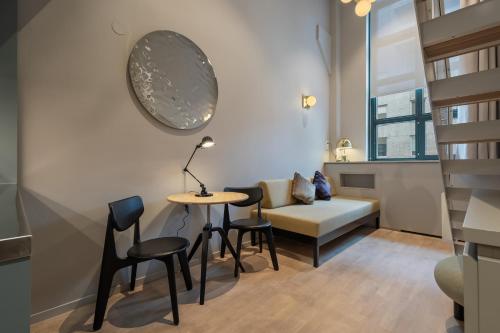 a living room with a table and chairs and a couch at Unity Hammarby Sjöstad - A Studio Hotel in Stockholm