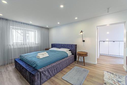 a bedroom with a blue bed in a room at Symphony Apartment with free parking in Kaunas