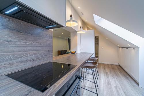 a kitchen with a counter top and some stools at Symphony Apartment with free parking in Kaunas
