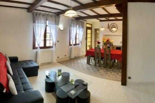 a living room with a couch and a table at Gite de Coquelicots avec Jacuzzi à Embreville in Embreville