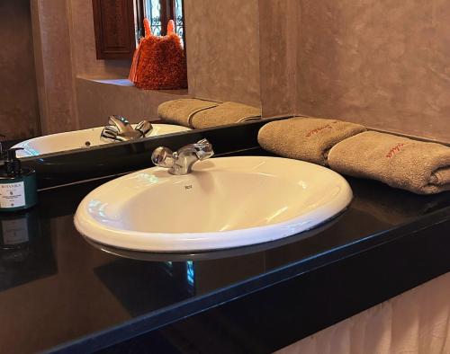 a bathroom counter with a sink and a mirror at Villa Sophia in Azib Oulad Lâdem