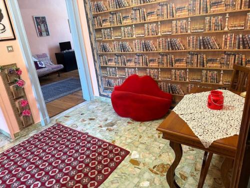 a room with a red chair and a table in a library at FRONTE PO in Turin