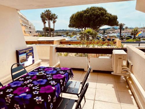 un balcon avec une table et des chaises et une vue dans l'établissement Village naturiste Cap D Agde T2 Port Nature 5 coursives avec parking, au Cap d'Agde