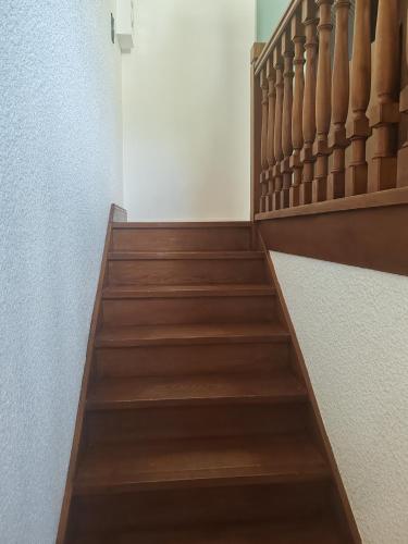 a stairwell with wooden steps and a white wall at Les deux cascades in Sainte-Eulalie