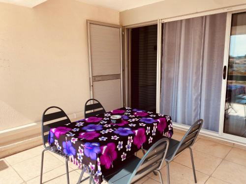 une table à manger avec un chiffon de table violet dans l'établissement Village naturiste Cap D Agde T2 Port Nature 5 coursives avec parking, au Cap d'Agde