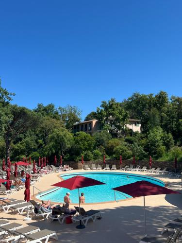 - un groupe de personnes assis sur des chaises à côté d'une piscine dans l'établissement Les Restanques Duplex 4 pers Les Magnolias Magnifique vue mer, à Grimaud