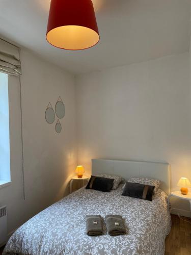 une chambre avec un lit avec deux pantoufles dessus dans l'établissement La Mascotte de Narbonne, 2 pieces proche Les Halles, à Narbonne