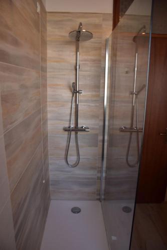 a bathroom with a shower with wooden walls at Appartamento Confine in Concordia Sagittaria
