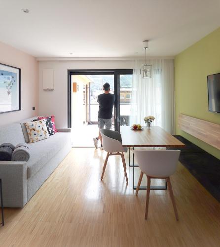 a man standing in a living room looking out the door at Apartment Luis 4 - Alpstay in Naturno