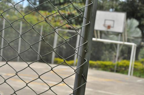 a chain link fence with a basketball hoop at Natural Glamping La Vega in La Vega