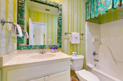 Un baño con lavabo, inodoro y espejo. en Island Sunrise, en Dauphin Island