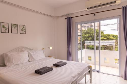a bedroom with a bed with two towels on it at Jida Place in Chiang Mai