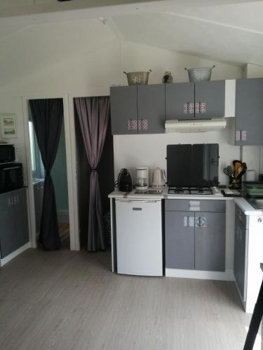 une cuisine avec une cuisinière et un comptoir dans l'établissement Mobilhome cool, à Pleurtuit