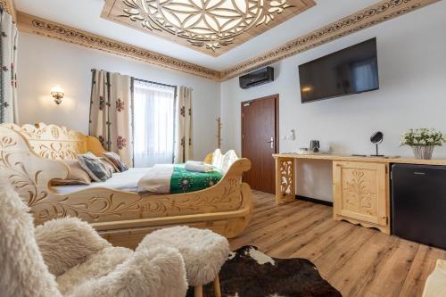a bedroom with a bed and a tv on the wall at Kilimy in Poronin