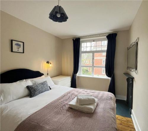Un dormitorio con una cama grande y una ventana. en Cavendish Charm Mayfair Apartment, en Londres