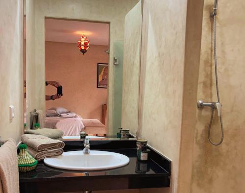 a bathroom with a sink and a mirror and a bed at Villa Sophia in Azib Oulad Lâdem