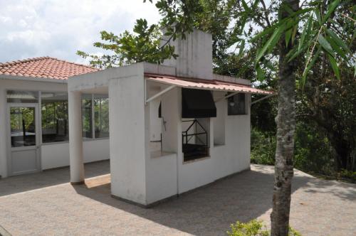 a white house with a kitchen and a tree at Natural Glamping La Vega in La Vega