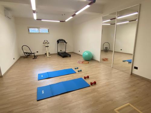 an empty room with a gym with blue mats on the floor at Villa Rita Guest House Torvaianica in Torvaianica