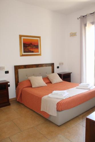 a bedroom with a large bed with orange sheets at Tenuta Ferraro Gallipoli in Gallipoli