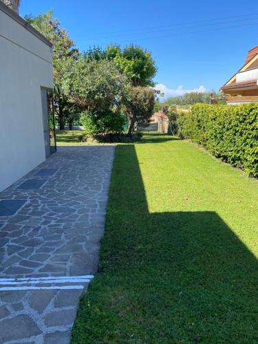 a garden with a stone walkway next to a building at Villa Rita Guest House Torvaianica in Torvaianica