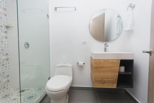 a bathroom with a toilet and a sink and a mirror at Guatapé Country House Hotel in Guatapé