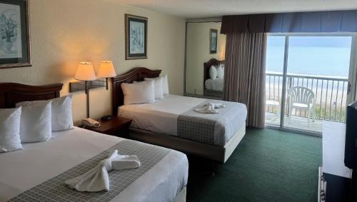 a hotel room with two beds and a balcony at Boardwalk Beach Resort in Myrtle Beach
