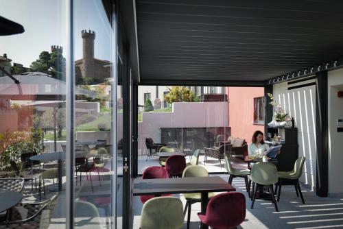 a woman sitting at a table on a patio at 3T Boutique Hotel in Ivrea