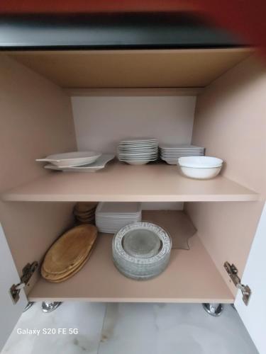 a shelf with plates and bowls in a cabinet at Casa Georgia in Tîrgu Ocna