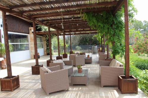 an outdoor patio with chairs and tables and a pergola at Tenuta Ferraro Gallipoli in Gallipoli