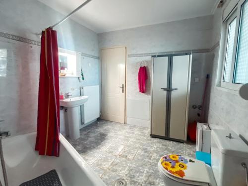 a bathroom with a tub and a toilet and a sink at Comfort Stay in Preveza