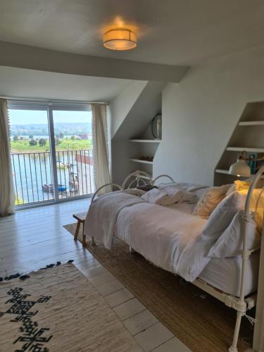 a bedroom with a bed and a large window at Luxury beachfront property Cockles-Sea View-private parking for 2 cars-sleeps 10 in Exmouth
