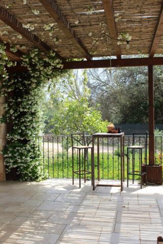a patio with two tables and a fence with ivy at Tenuta Ferraro Gallipoli in Gallipoli