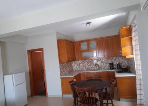 a kitchen with wooden cabinets and a table at Vila Rapo in Himare