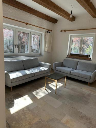 a living room with two couches and a table at Landhaus Eugenie in Garmisch-Partenkirchen