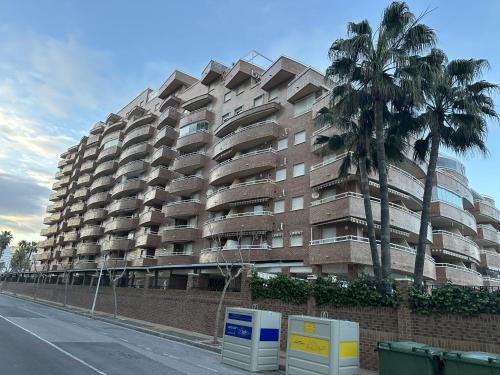 a tall building with palm trees in front of it at Apartamentos Marina Park in Oropesa del Mar