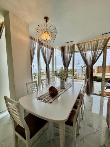 a dining room with a white table and chairs at TIS, Green Coast in Palasë