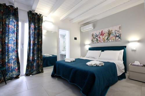 a bedroom with a blue bed with towels on it at Ivi's House in Palermo