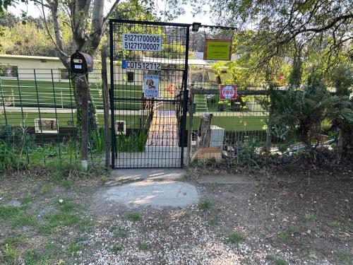 a gate in a park with signs on it at L'Arlésienne in Arles